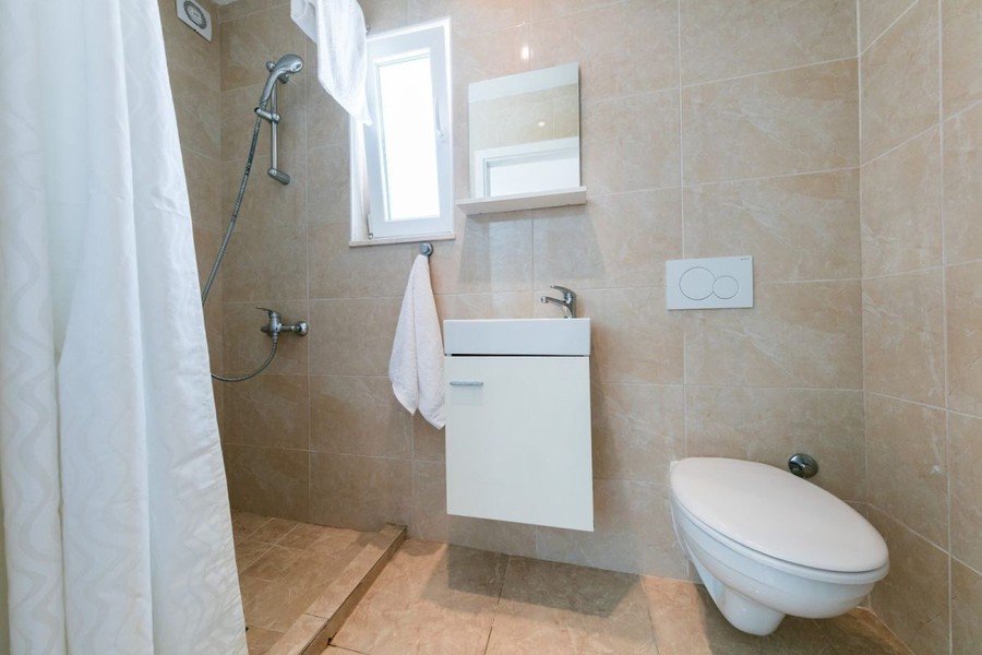 Badezimmer mit Dusche und Fenster