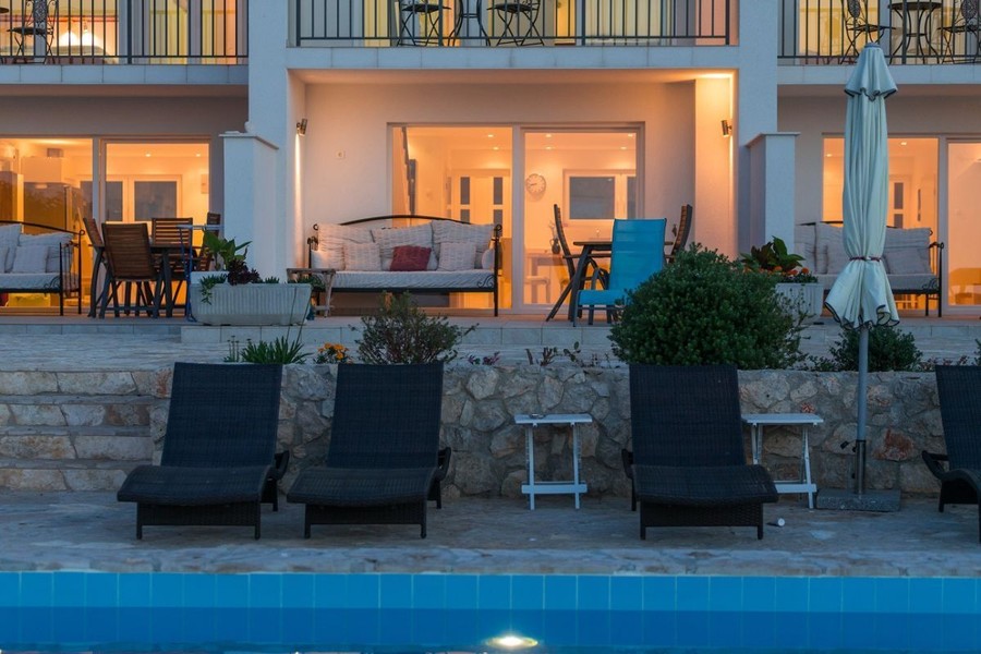 Terrassen der Wohneinheiten mit Liegen am Pool