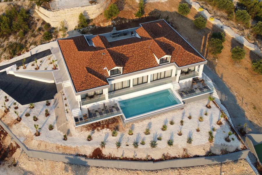 Villa mit Pool und bepflanzten Außenanlagen von oben