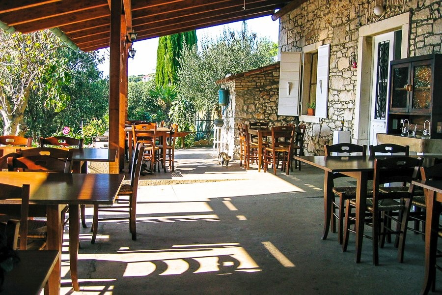Überdachte Terrasse mit Tischen am Steinhaus