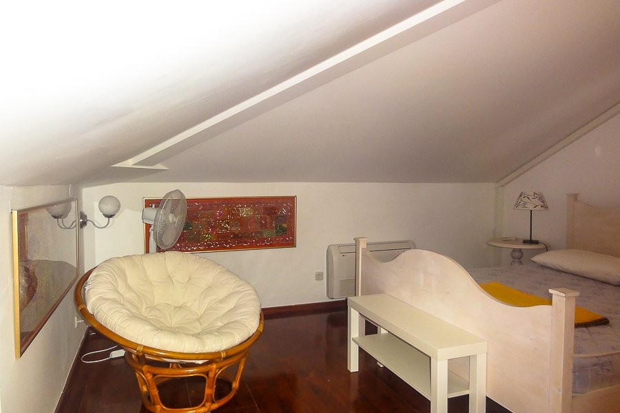 Dachzimmer mit Bett und Sessel