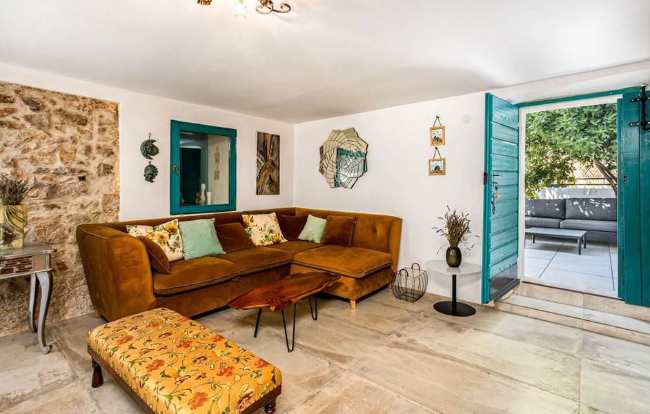 Wohnzimmer mit Ecksofa und Natursteinwand