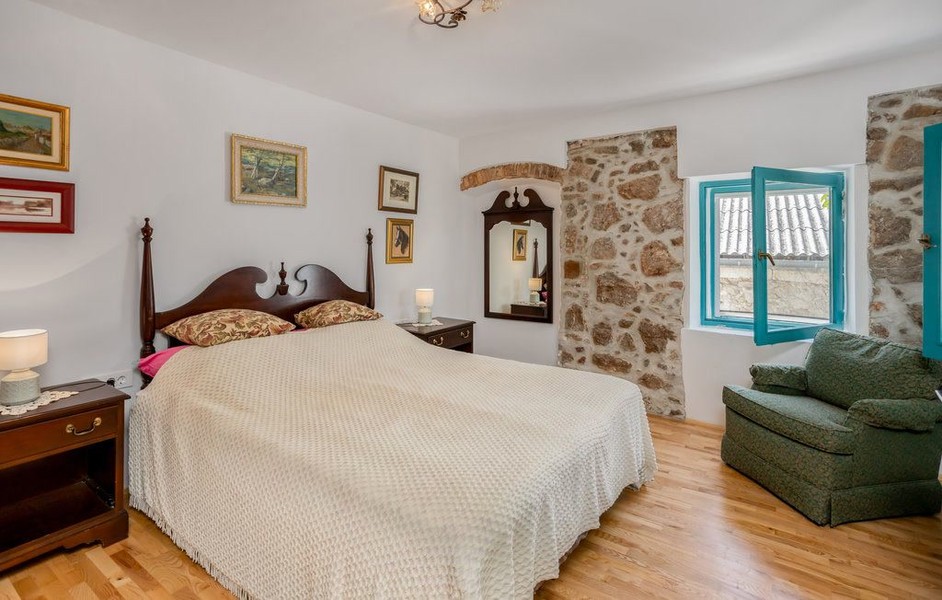 Schlafzimmer mit Holzbett und Sessel