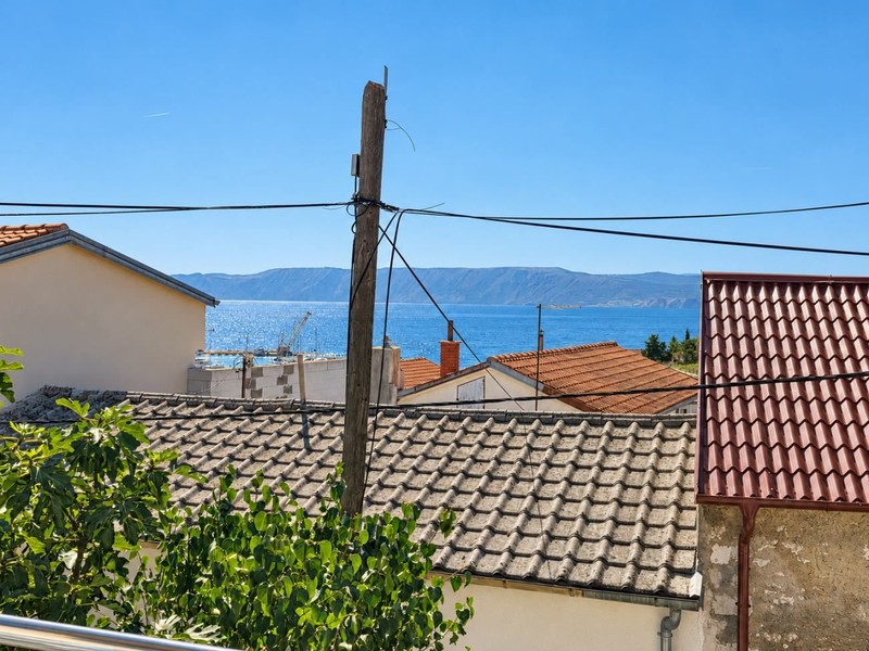 Blick über die Dächer auf das Meer und die Insel Krk