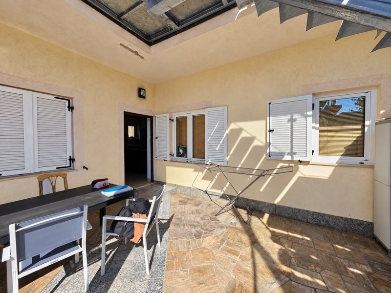 Überdachte Terrasse mit Tisch und Stühlen