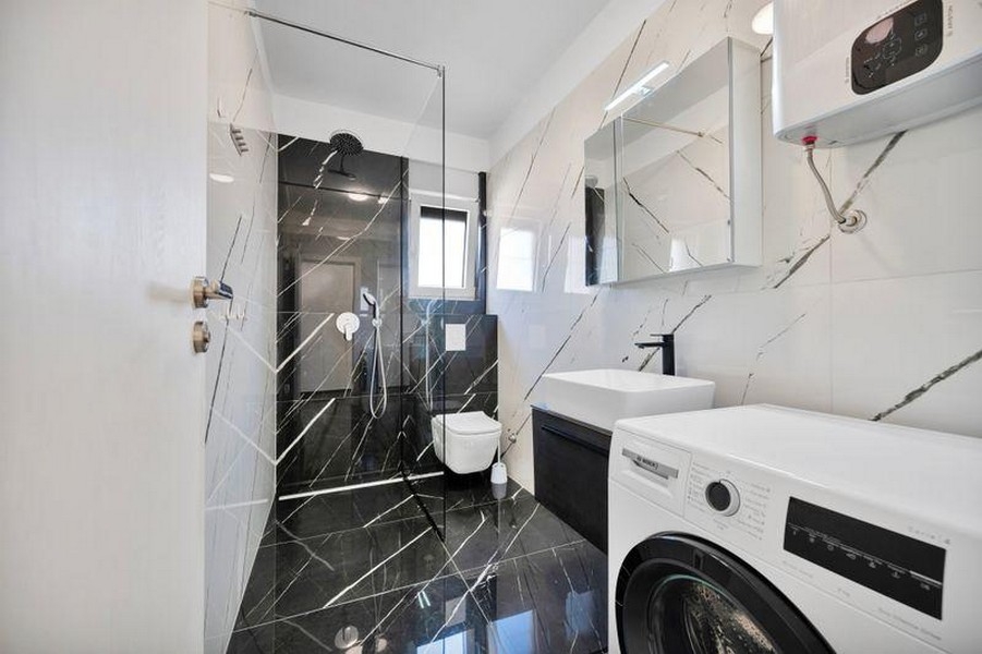Badezimmer mit Dusche und Waschmaschine