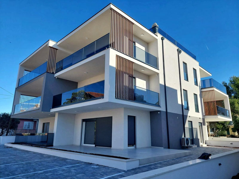 Moderne Hausfassade mit Glasgeländern vor blauem Himmel