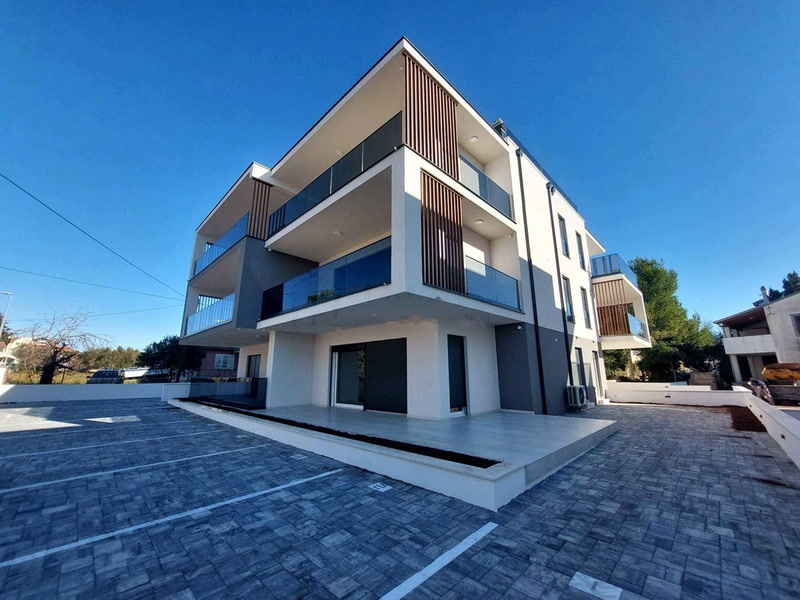 Wohnhaus mit Terrasse und markierten Stellplätzen im Vordergrund