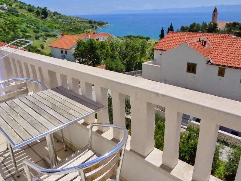 Balkon mit Blick auf die grüne Landschaft und das Meer von der Immobilie A2999 in Kroatien auf der Insel Brac.