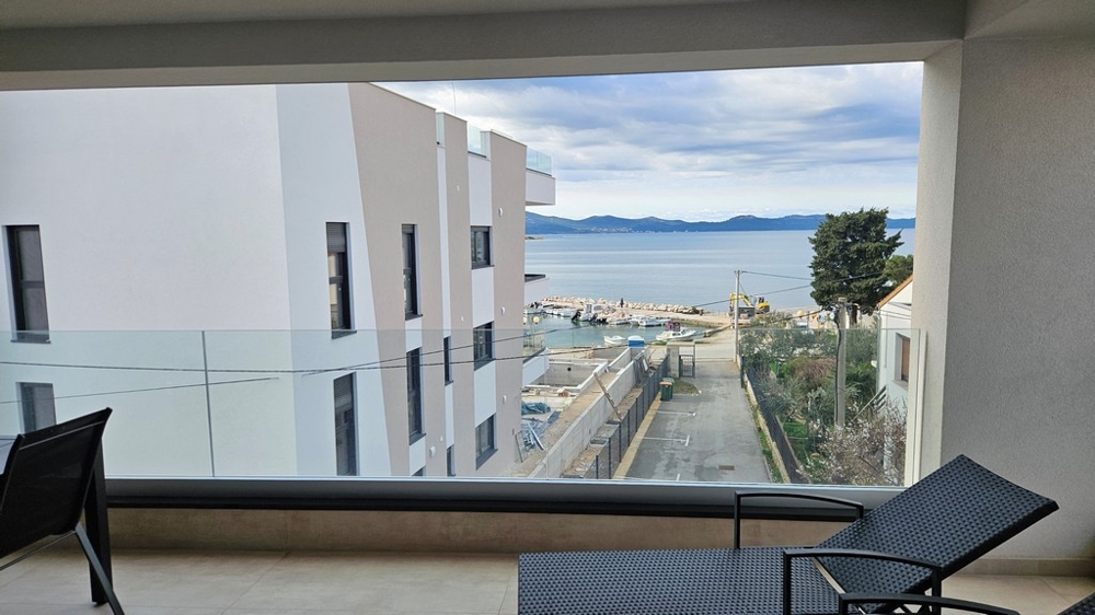 Essbereich mit Tisch und Stühlen in einem Penthouse zum Verkauf in Zadar, Kroatien, mit Fensterblick auf das Meer