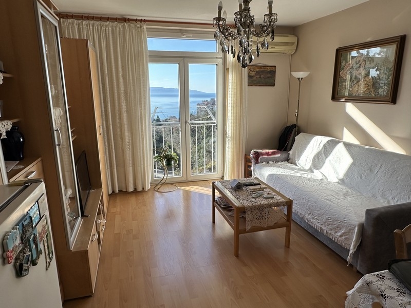 Wohnzimmer mit Sofa und Balkontüren mit Meerblick, innerhalb einer zum Verkauf stehenden Wohnung in Rijeka