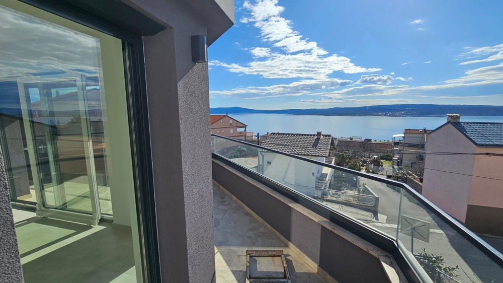 Seitenblick auf den Balkon des Verkaufs-Apartments in Crikvenica mit klarem Himmel und Meerblick