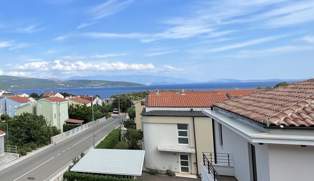 Blick auf das Meer und rote Dachziegel von Immobilien in Kroatien bei klarem Himmel