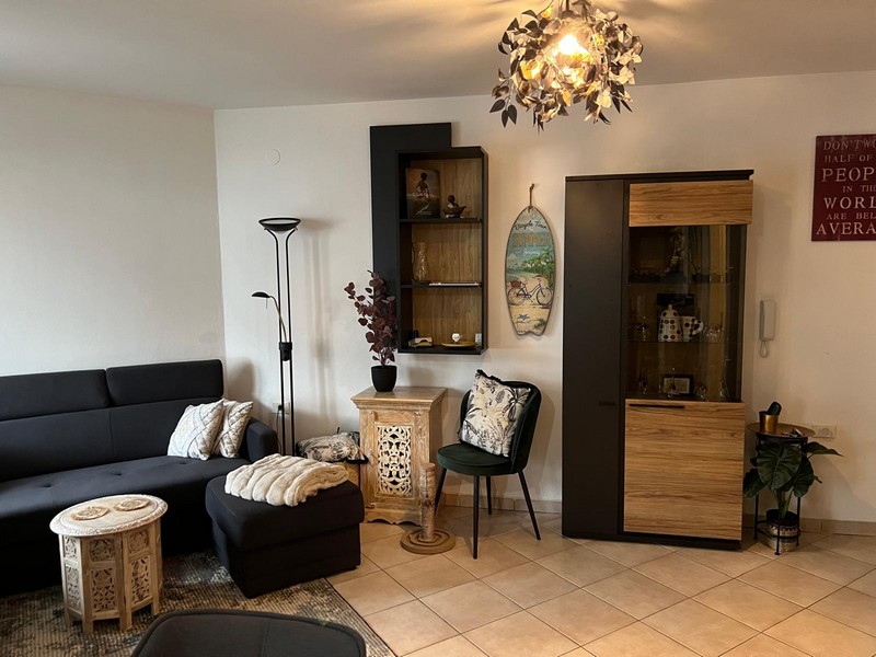 Wohnbereich mit Vitrine, Wandregal und Stehlampe