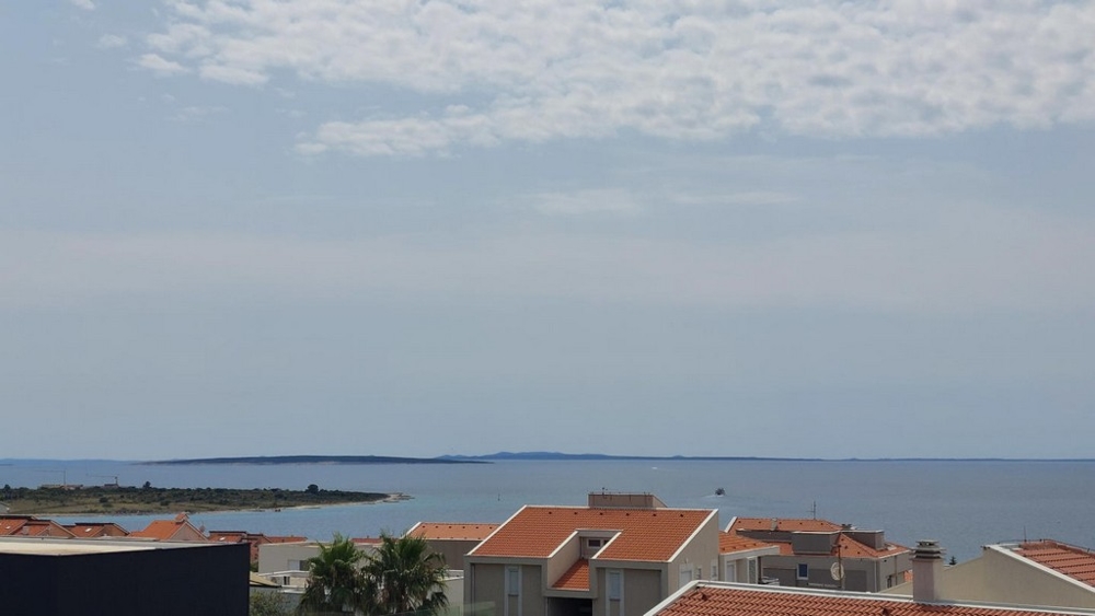 Panorama Scouting A3294 - Immobilien Kroatien: Blick auf das Meer und die Inseln im Hintergrund, mit orangefarbenen Dächern von Häusern im Vordergrund