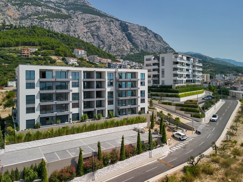 Immobilien in Kroatien, Makarska, Appartement mit Meerblick: Luftbild eines modernen Wohnkomplexes mit Berg im Hintergrund