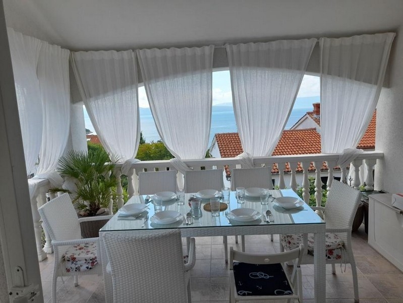 Große Terrasse mit Meerblick und einem schönen Esstisch.