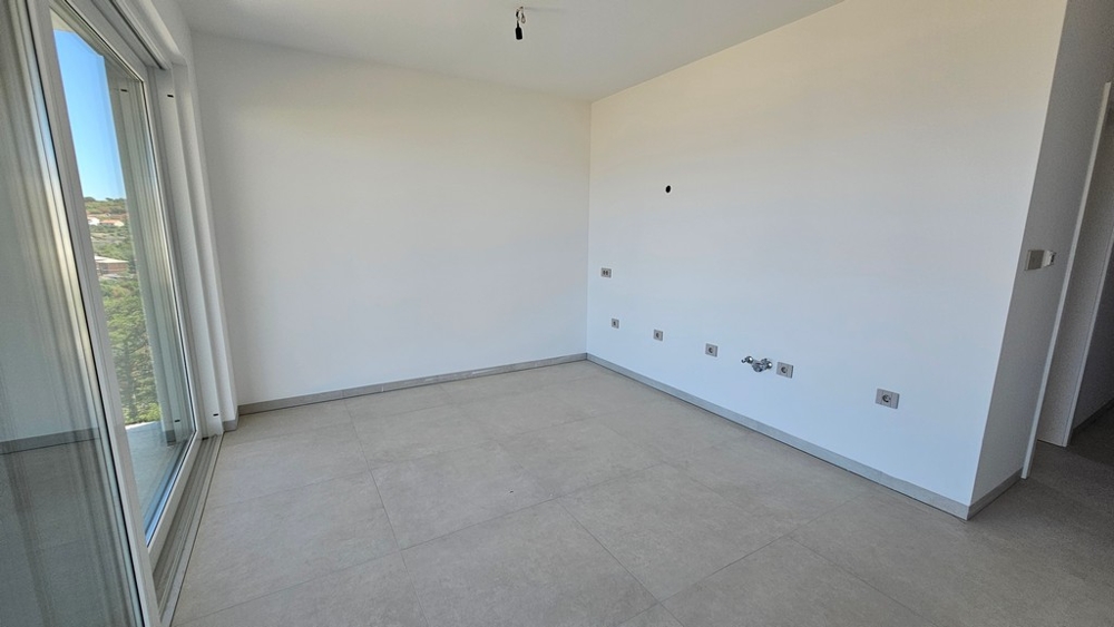 Heller Wohn- und Küchenbereich mit Glastür im Neubau A3480 in Vrbnik