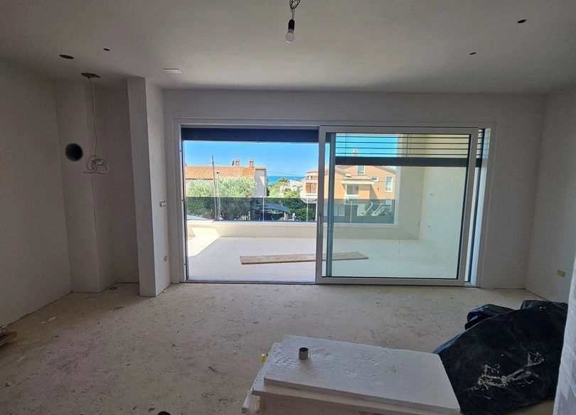 Blick vom Wohnzimmer auf die Terrasse und das Meer.