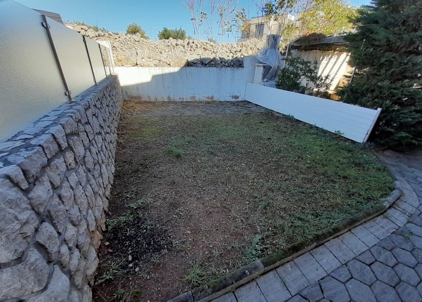 Kleiner Gartenbereich mit Steinmauer und Rasenfläche
