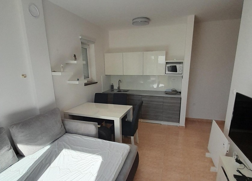 Moderne Küchenzeile mit Ober- und Unterschränken sowie Essbereich