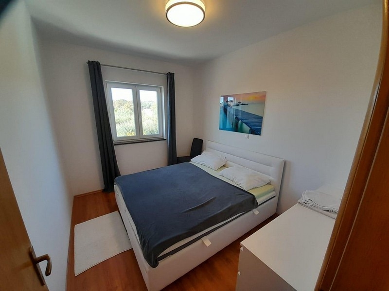 Schlafzimmer mit Doppelbett, Fenster und Wandbild