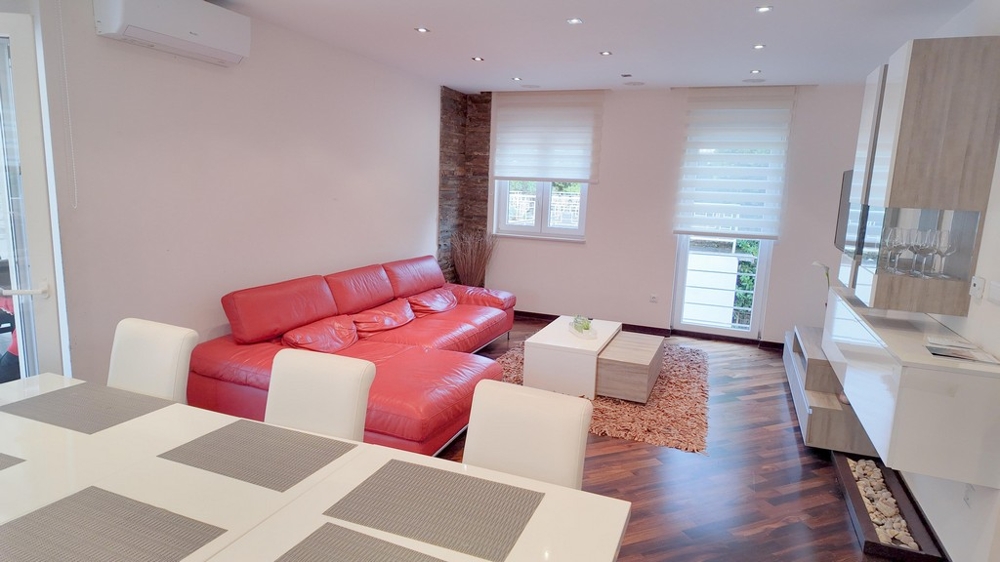 Wohnzimmer mit rotem Ledersofa und stilvollem Design