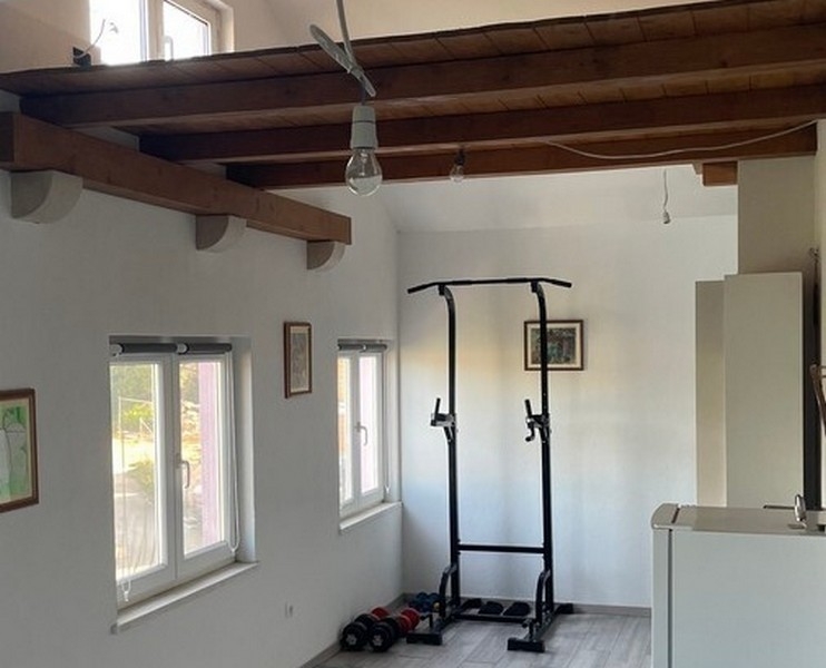 Fitnessbereich unter Holzbalken im Wohnraum