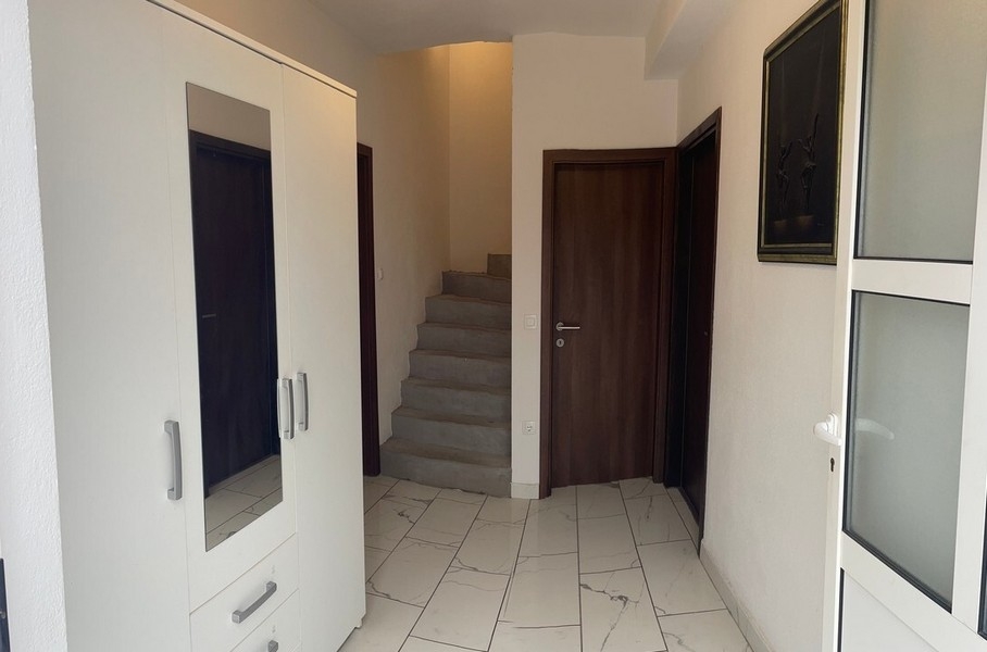 Eingangsbereich mit Treppe und weißen Einbaumöbeln