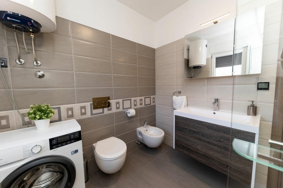 Badezimmer mit Waschmaschine und Dusche