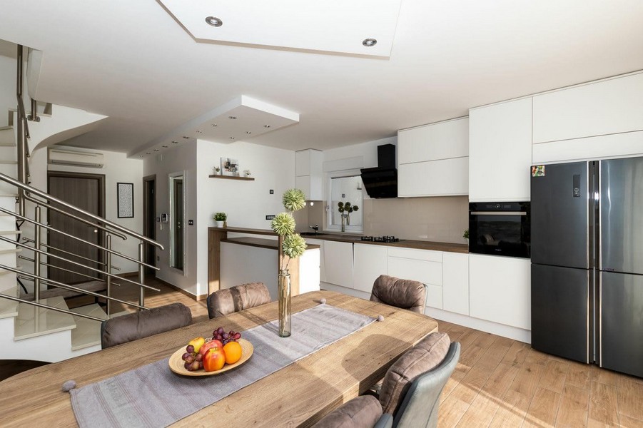 Moderne Küche mit Essplatz und Zugang zur Treppe