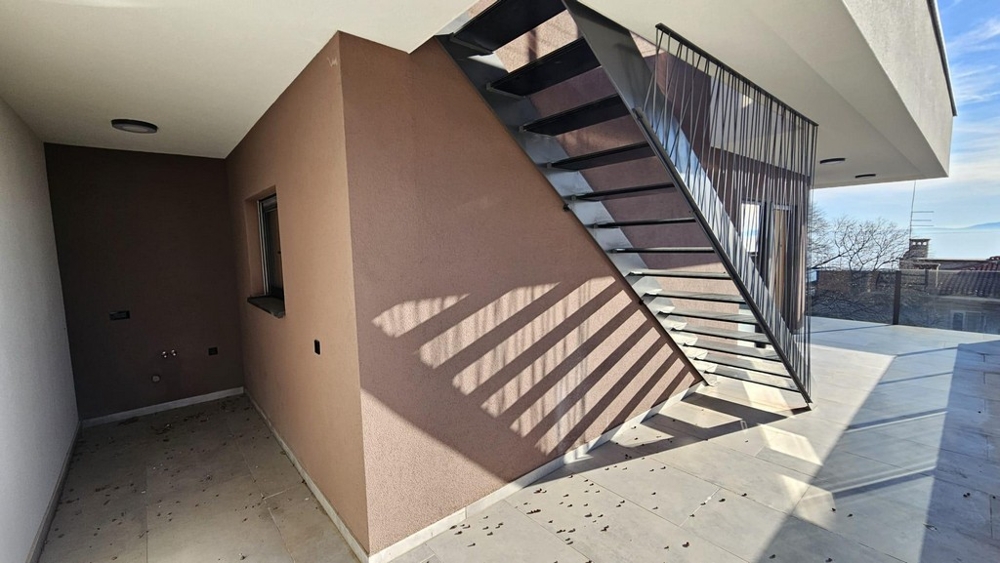 Überdachte Außenfläche mit Metalltreppe