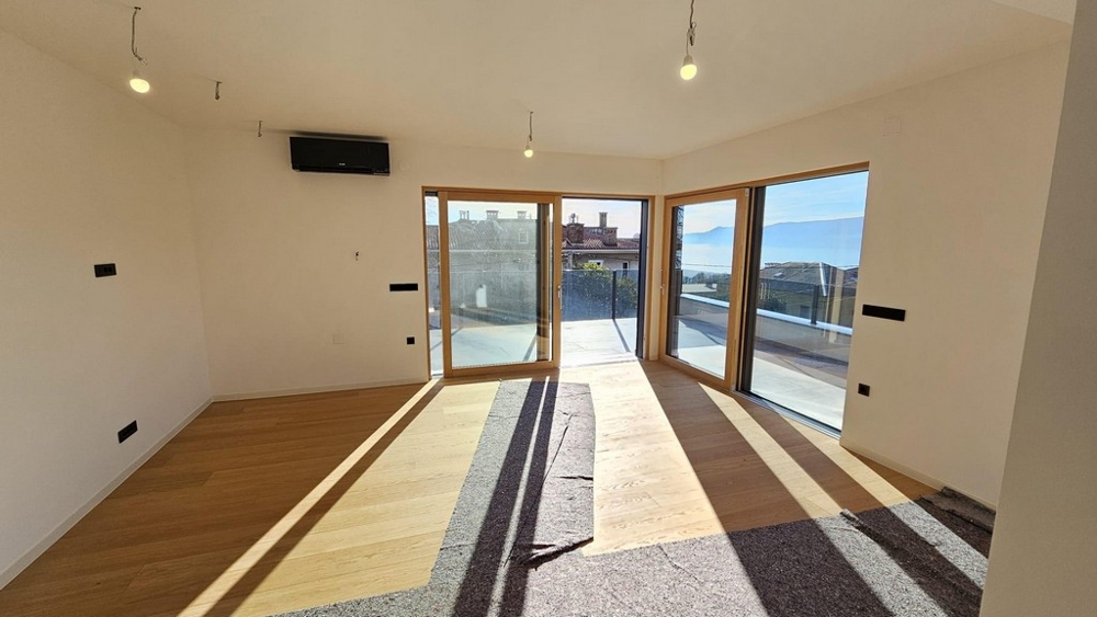Wohnbereich mit großen Fensterfronten und Terrasse