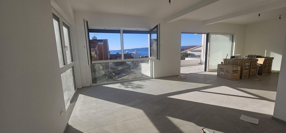 Wohnzimmer mit großen Fensterflächen und Meerblick