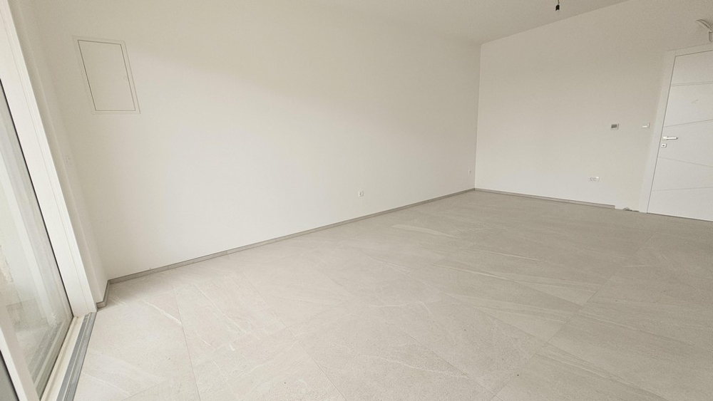 Schlafzimmer mit hellen Wänden und Fliesenboden