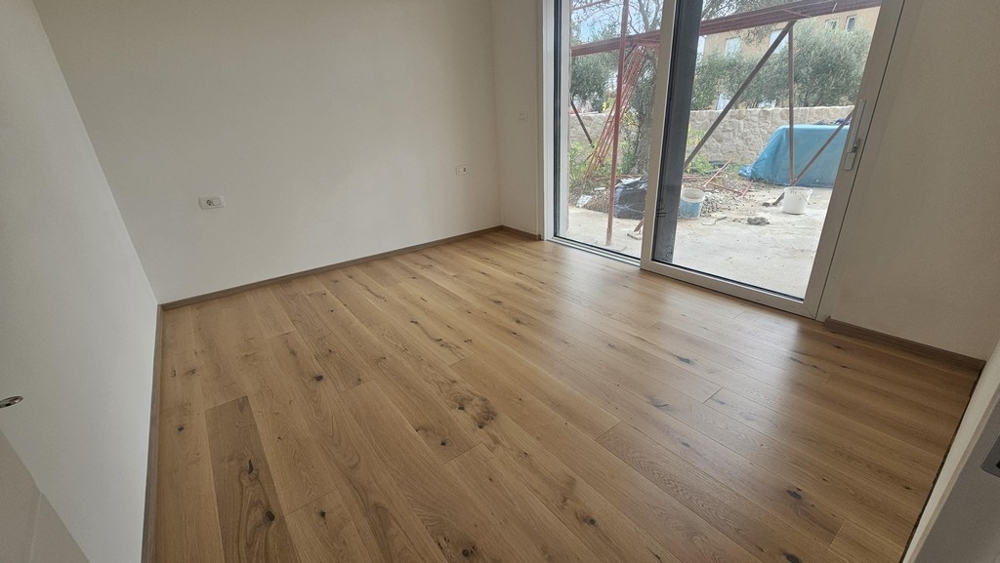 Schlafzimmer mit Parkettboden und Gartenzugang