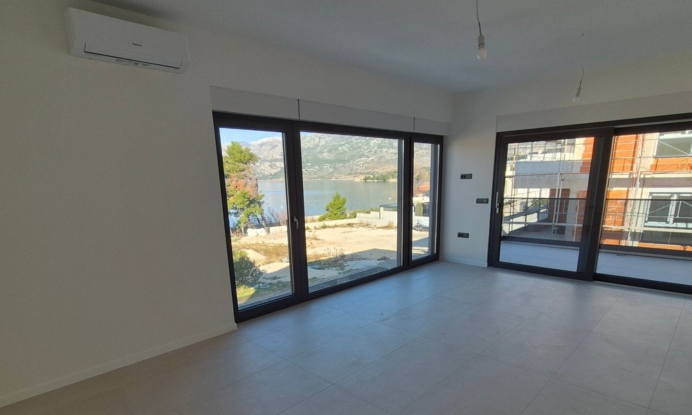 Wohnzimmer mit großen Fensterfronten und Meerblick