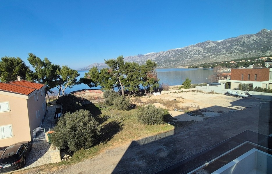 Blick auf Meer, Bäume und Nachbarbebauung