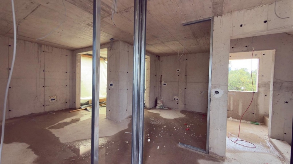 Offener Wohnbereich im Rohbau mit Fenster und Meerblick