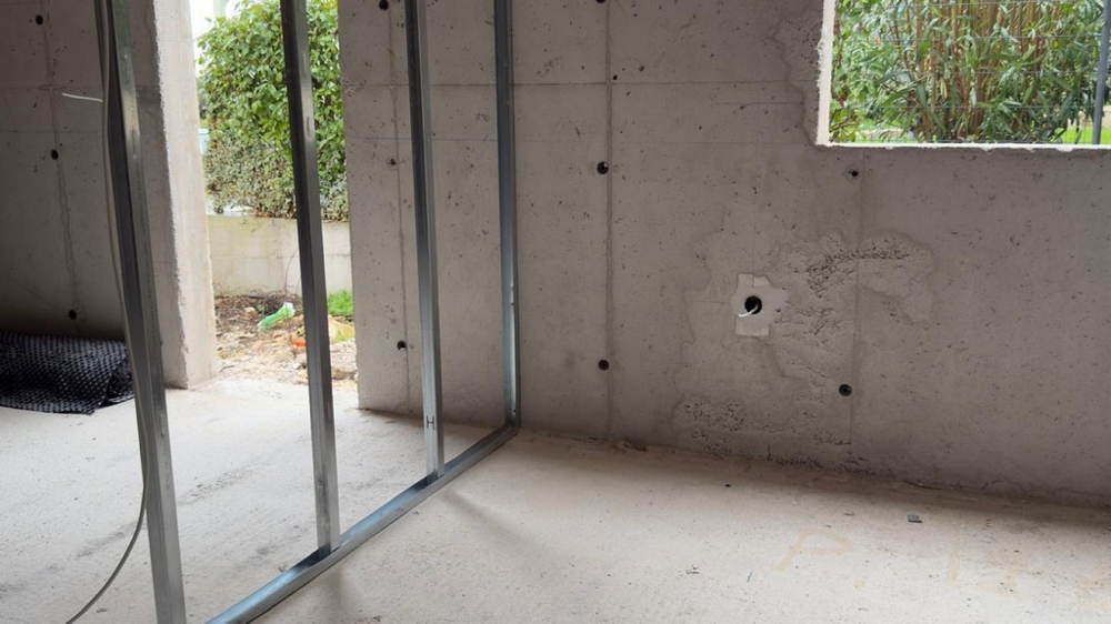 Raum im Rohbau mit Fenster und Zugang nach außen