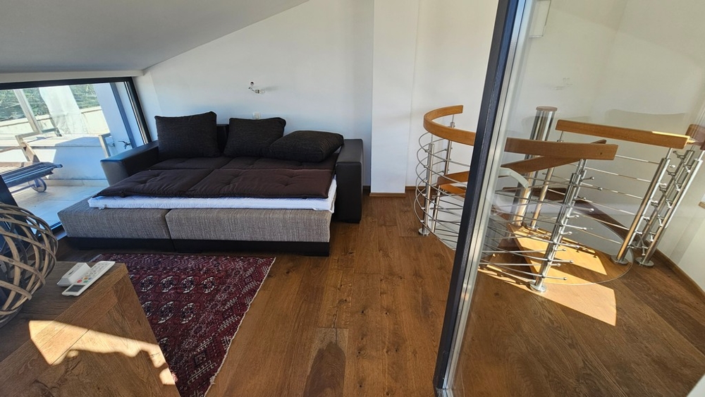 Galerie mit Sofa und Wendeltreppe zur unteren Ebene