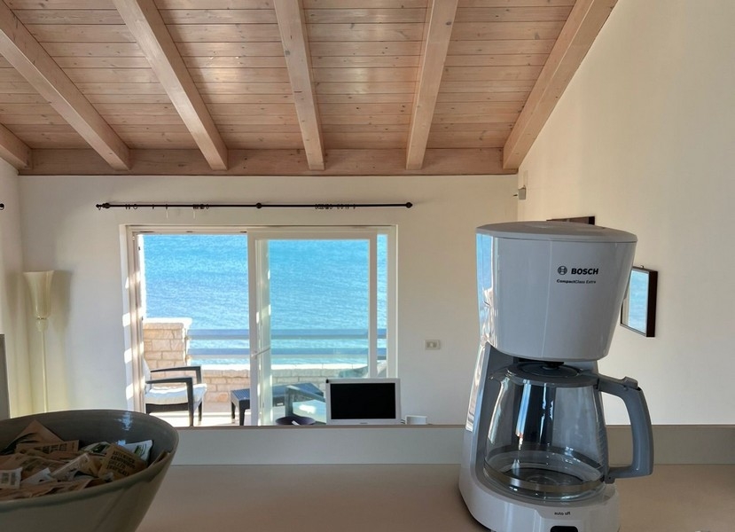 Blick von der Küche über den Wohnbereich zur Terrasse und zum Meer