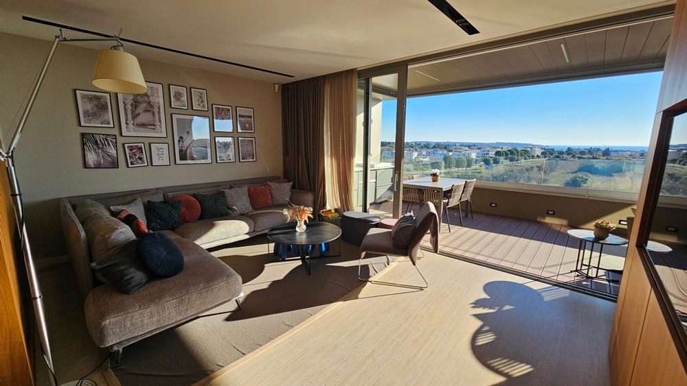 Wohnzimmer mit großer Glasfront und Meerblick