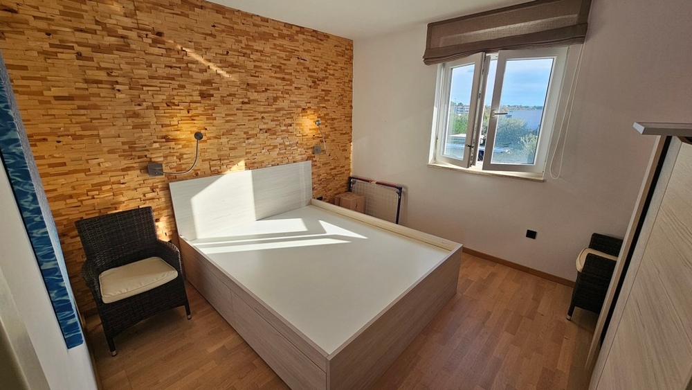Schlafzimmer mit Holz-Akzentwand und Meerblick