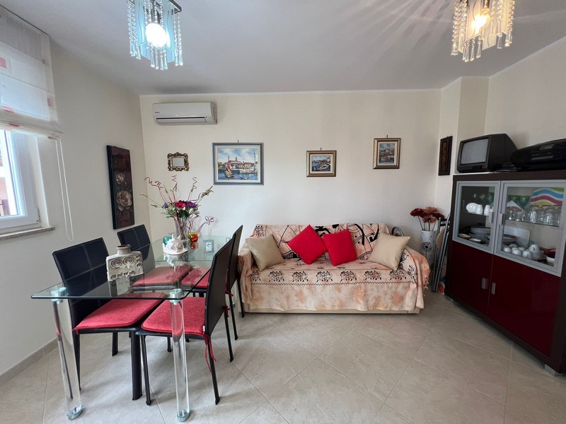 Wohnzimmer mit Sofa und Glas-Esstisch