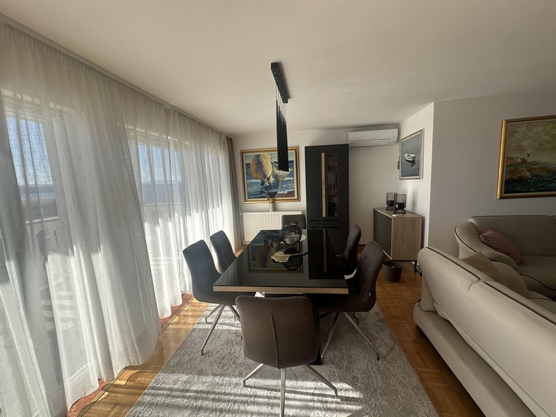 Essbereich mit Tisch und bodentiefen Fenstern