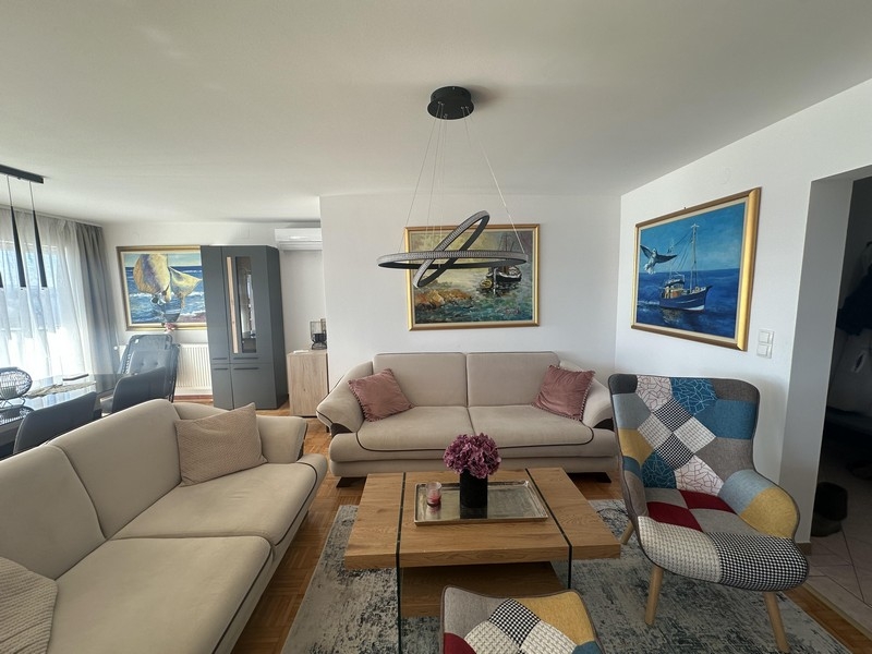 Heller Wohnraum mit Sofa, Couchtisch und Wandbildern