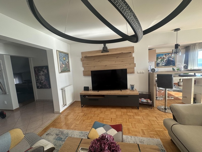 Wohnzimmer mit TV-Bereich und Durchgang zur Küche