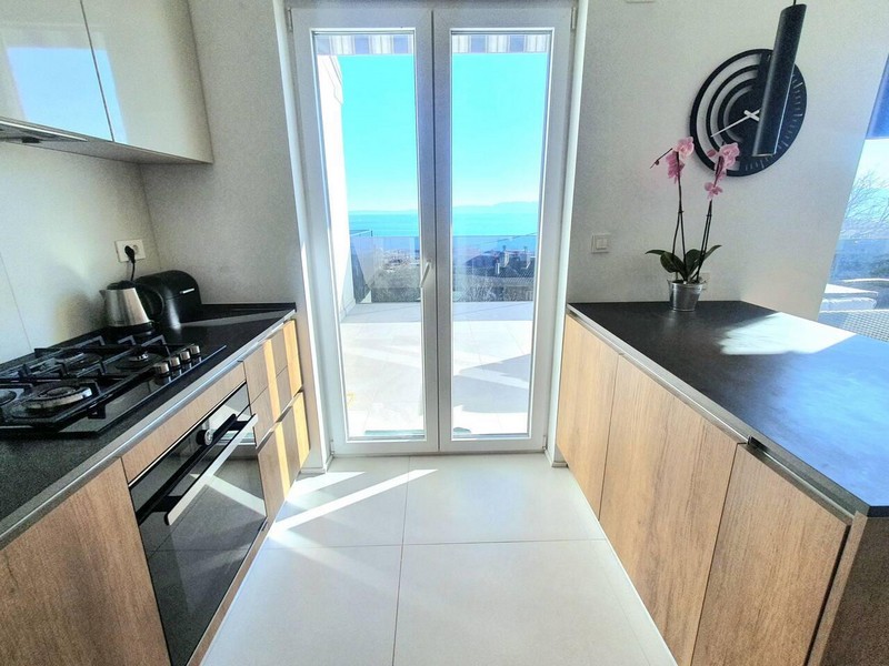 Küche mit Orchidee und Terrassentür zum Meer