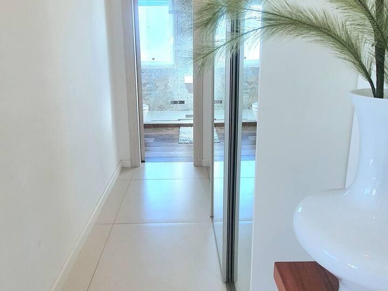 Heller Flur mit Spiegelschrank und Blick ins Bad